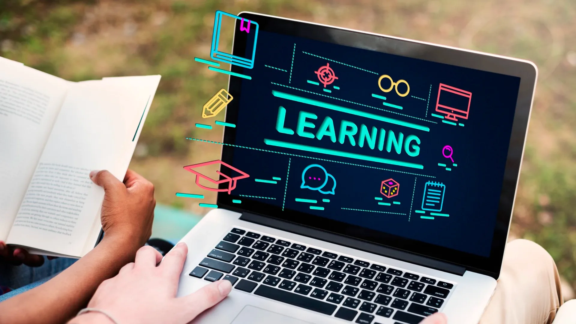Person holding an open book beside a laptop displaying the word Learning surrounded by education icons