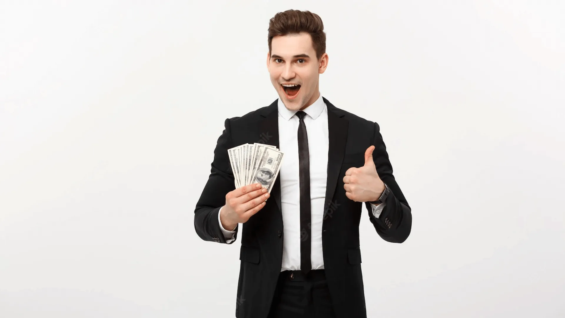 Smiling man in a suit holding a fan of dollar bills and giving a thumbs up